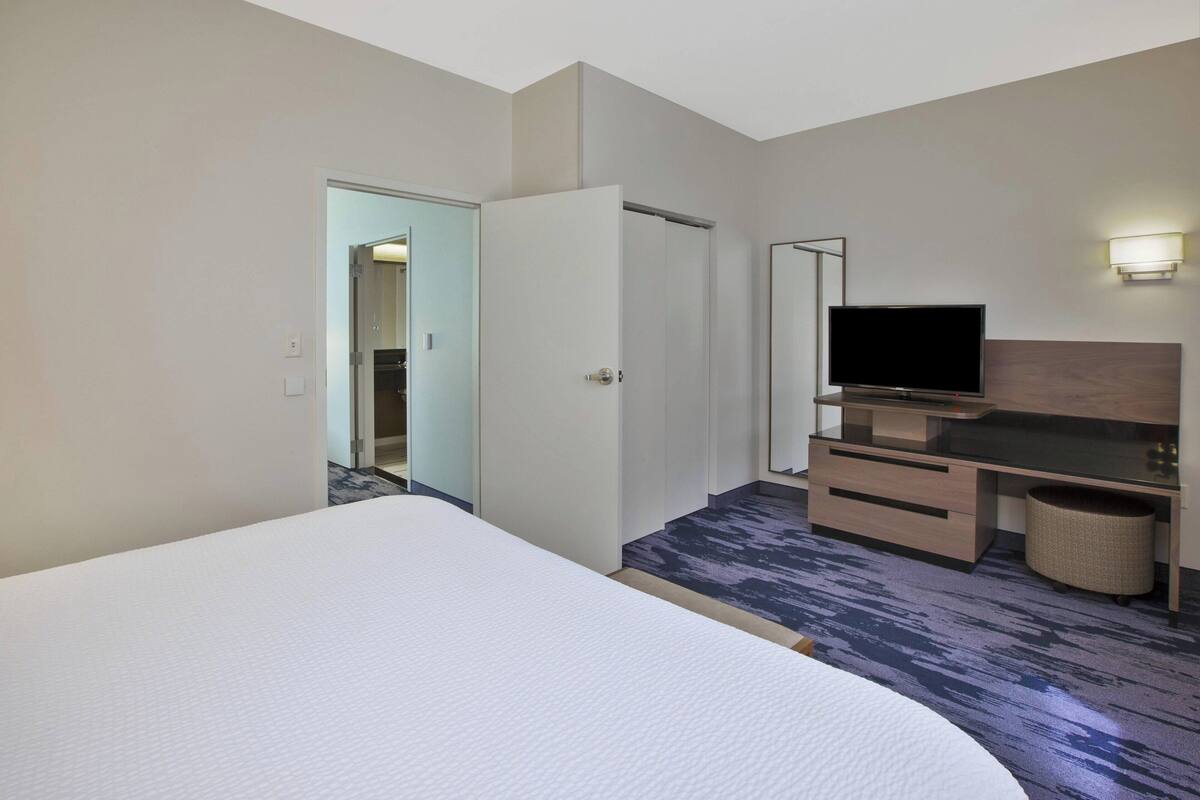 Une chambre d’hôtel équipée d’un lit, d’une télévision, d’un bureau et d’une armoire.