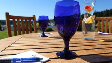A wooden table with two blue glassware items and a pen on a notepad.