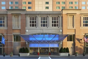 Ein Seaport Hotel mit moderner Gestaltung, großen Fenstern und einer blauen Markise.