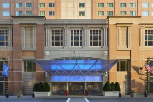 Hotel Seaport con ingresso moderno, ampie finestre e un tendone blu.