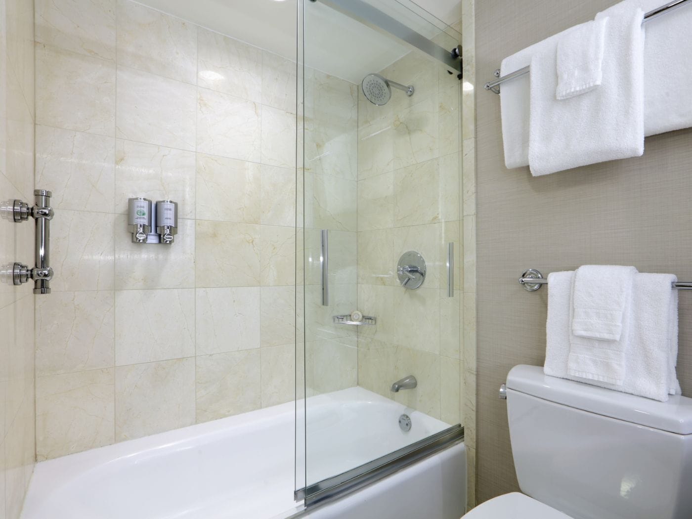 Un baño moderno con ducha envuelta en vidrio, bañera y retrete.