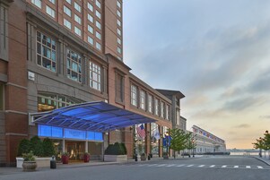 A Seaport Hotel with a modern brick facade, large windows, and a covered entrance area.
