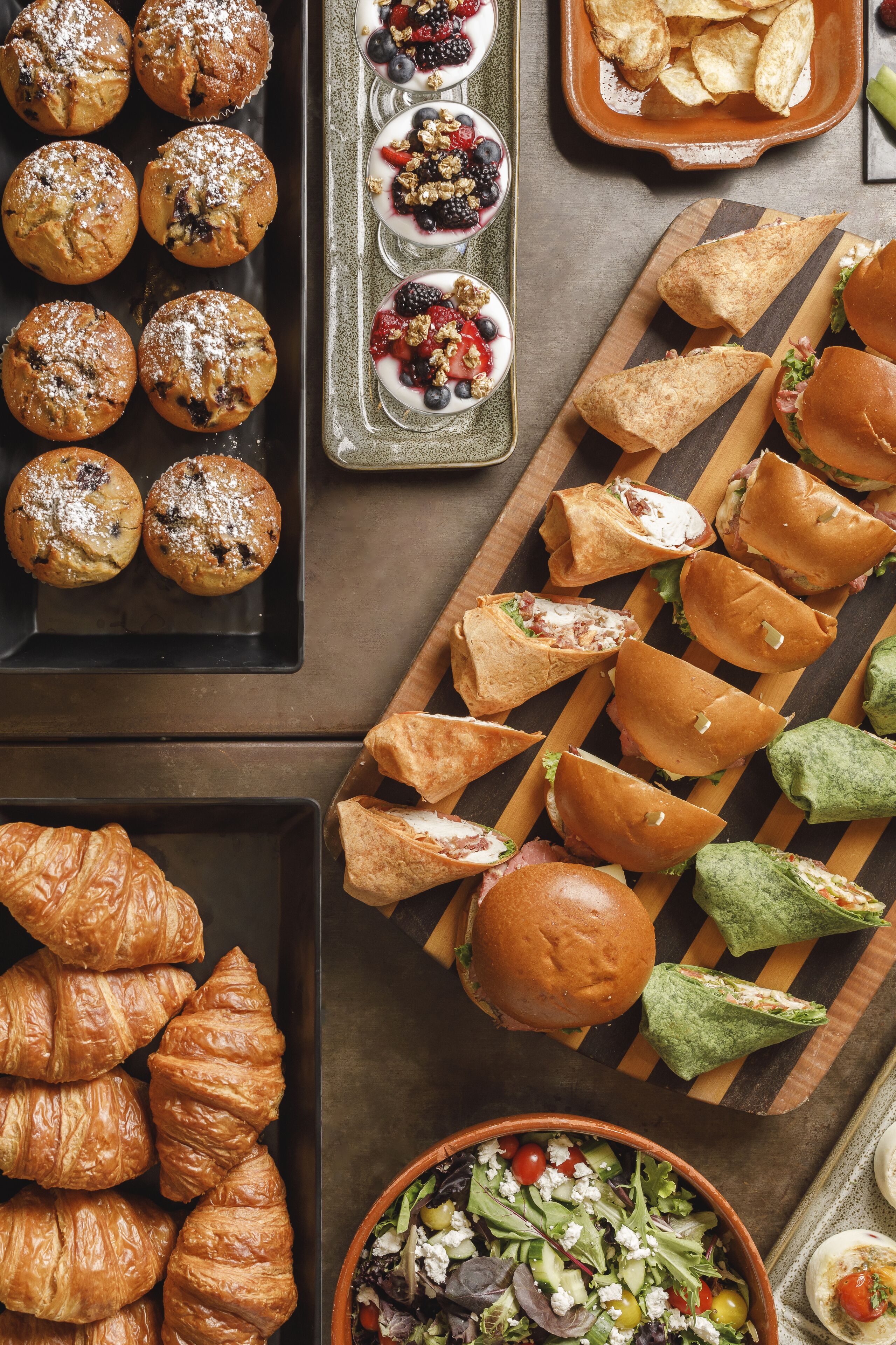 A variety of baked goods including muffins, croissants, and sandwiches.