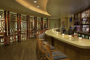 A bar area with wooden chairs and a curved counter.