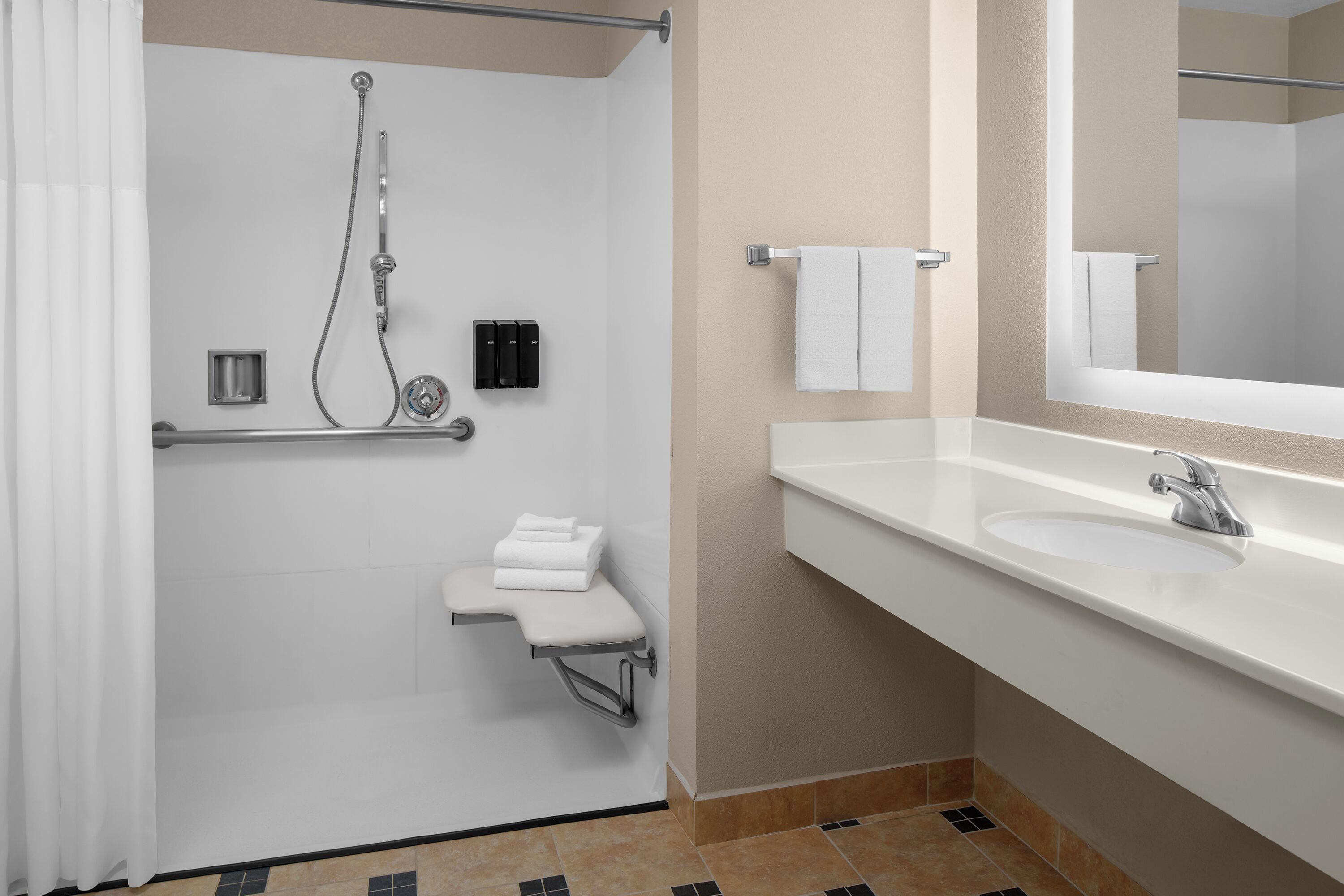 Un baño moderno con ducha, lavabo y espejo.