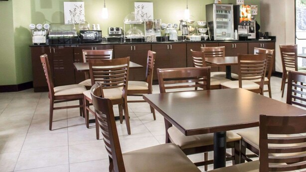 Un restaurant doté d’un mur végétal, d’un espace dédié au café et de tables et chaises en bois.