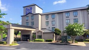 Un hôtel Sleep Inn doté d’une entrée principale, de nombreuses fenêtres et d’un parking.