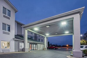 A gas station with a covered canopy, a red truck, and a building with multiple windows and a door. - Baymont by Wyndham Milan (Milan)