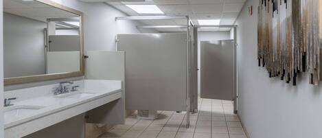 Ein modernes Badezimmer mit zwei Waschbecken, einem großen Spiegel und einer Duschkabine.