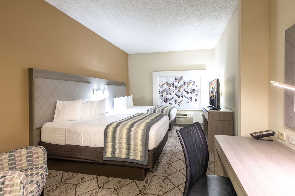 Une chambre d’hôtel comprenant un lit, des tables de chevet, un bureau et une chaise.