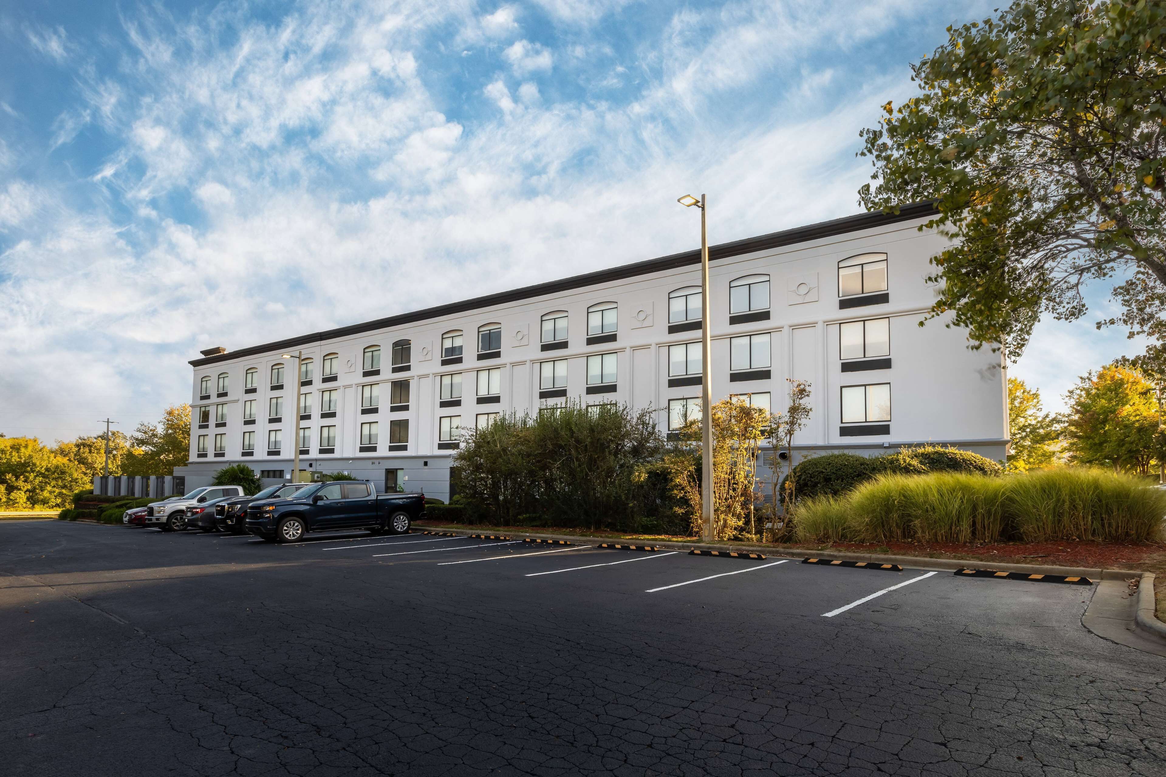 A modern building with a parking lot and several cars.