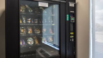 A vending machine with snacks and drinks, a payment keypad, and a coin slot.