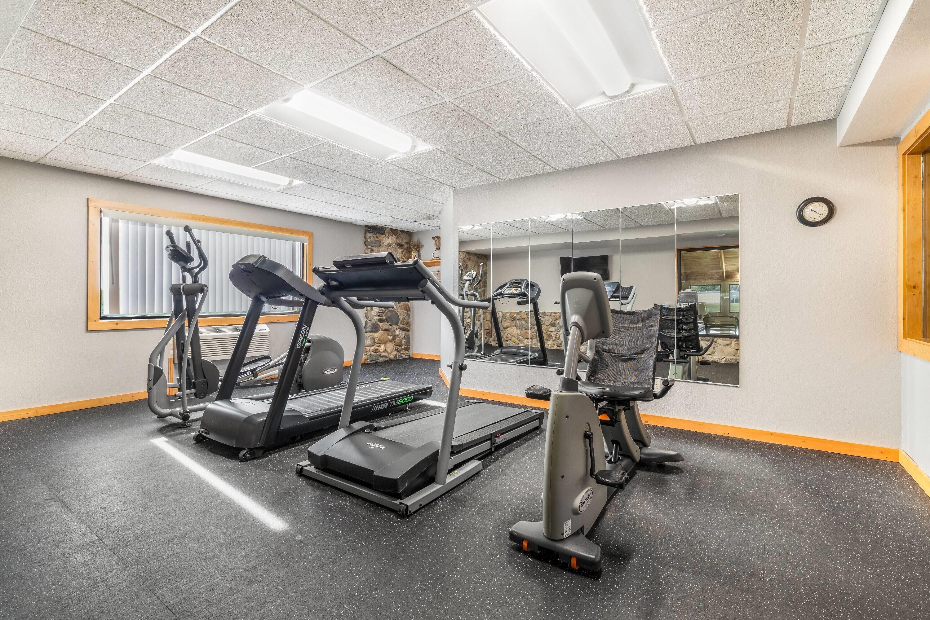 A gym with treadmills, elliptical machines, and weight equipment.