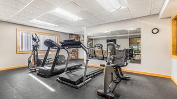 A gym with treadmills, elliptical machines, and weight equipment.