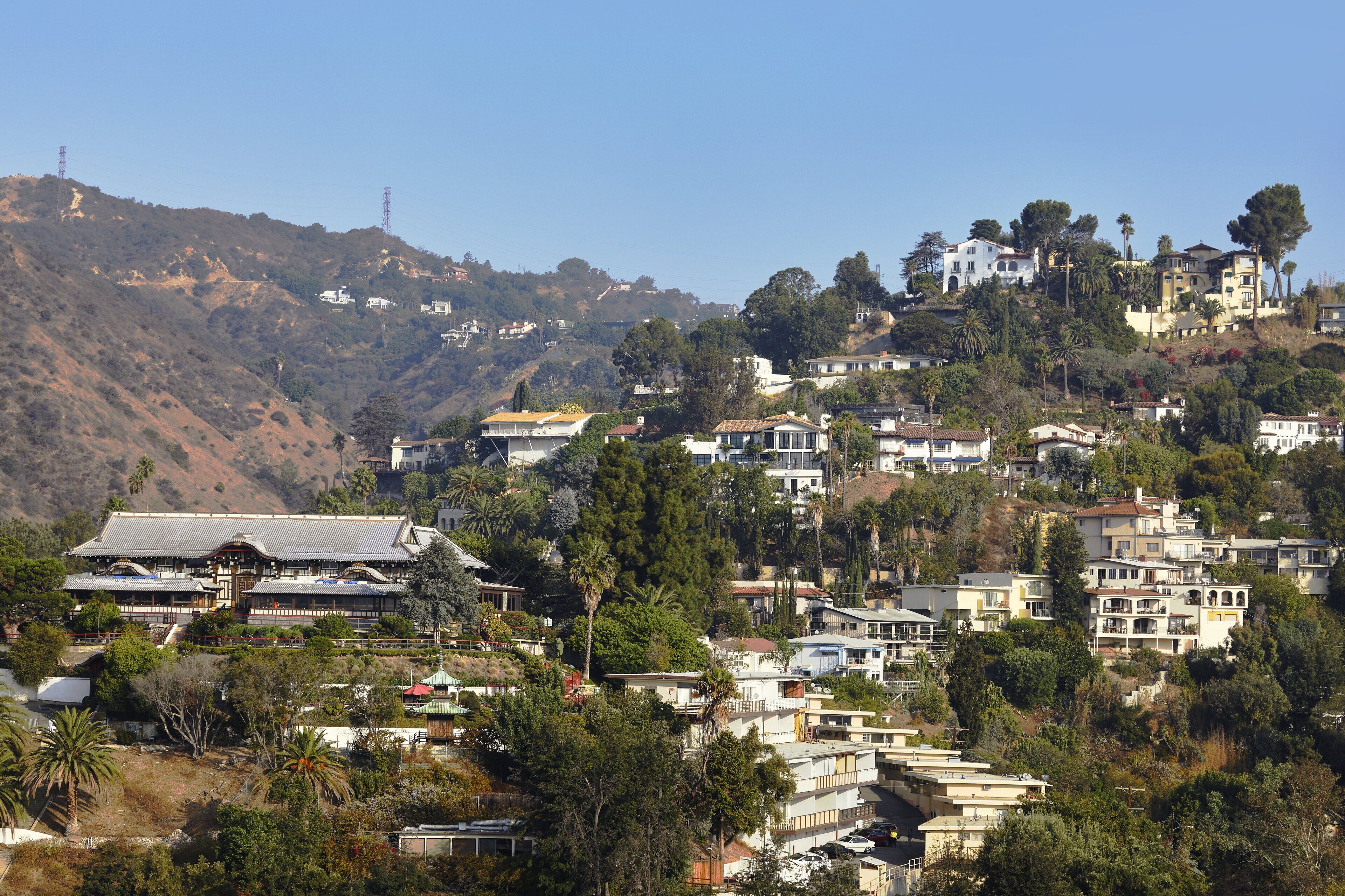 A residential area with houses on a hillside, including a traditional building with a tiled roof.