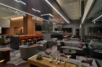 A hotel room with two beds, a sofa, a chair, a coffee table, and a view of the city. at Loews Hollywood Hotel