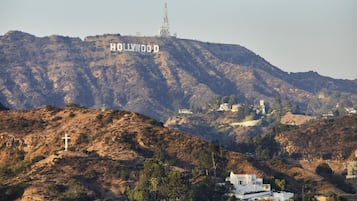 Uma colina com o letreiro Hollywood e um edifício branco com telhado vermelho.