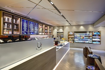 A modern hotel lobby with seating areas, a bar, and a fireplace. at Loews Hollywood Hotel