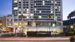 Un hôtel de grande hauteur au design moderne, reconnaissable à son grand panneau « LOEWS » placé en haut de l’édifice.