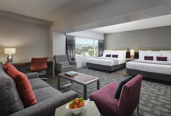 A modern, well-lit retail space with a central display counter, refrigerated beverage section, and neatly organized shelves. at Loews Hollywood Hotel
