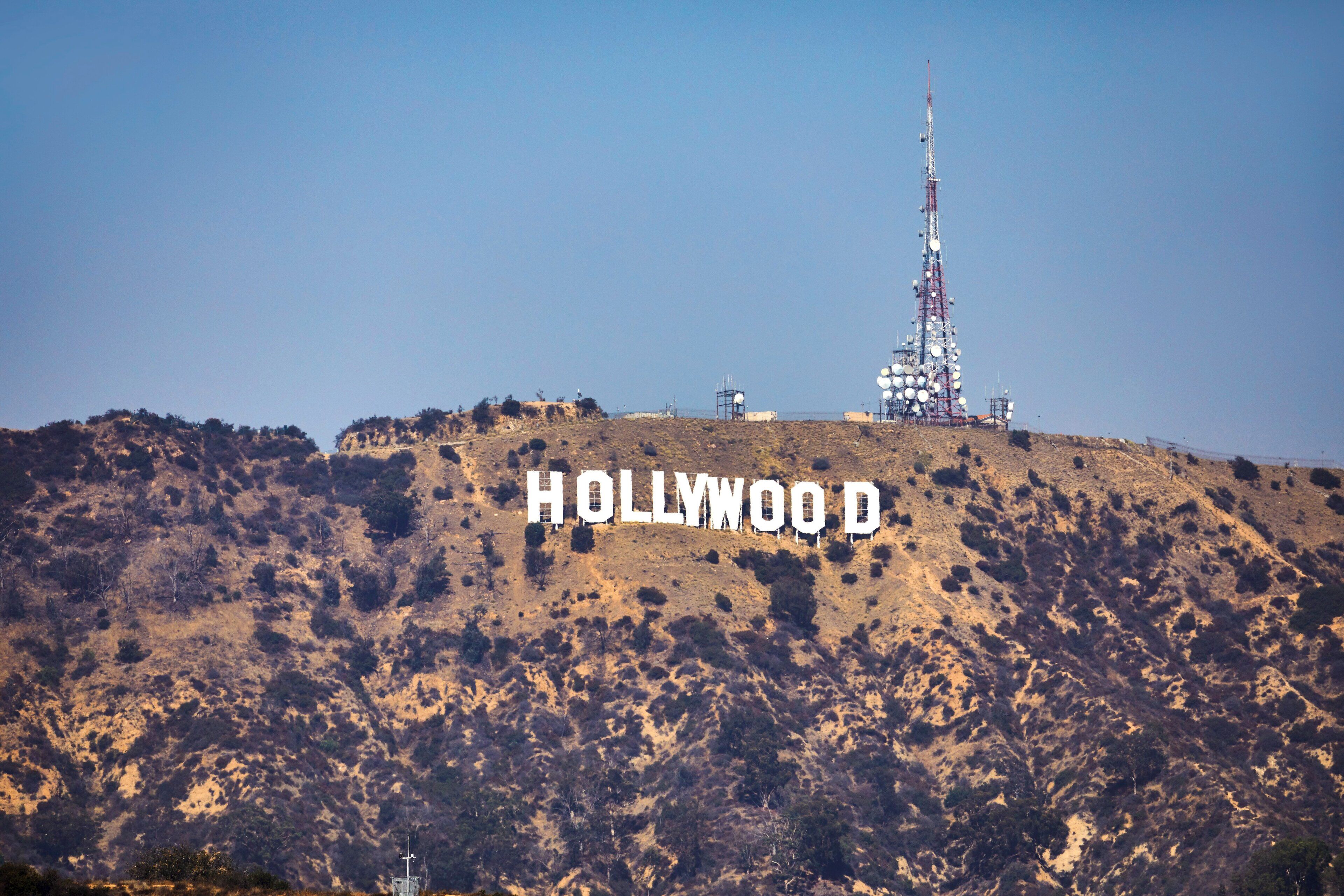 The Hollywood sign on a hill with a clear sky.