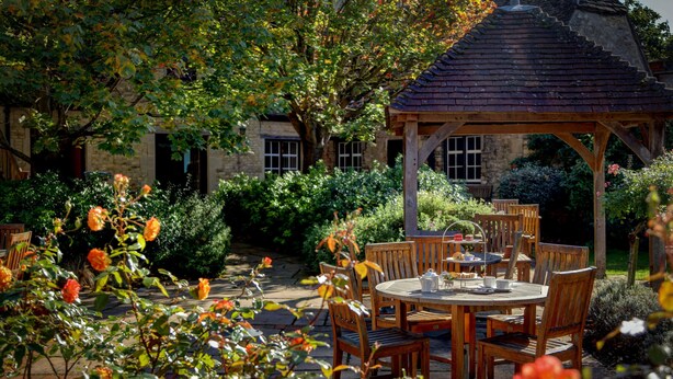 A garden with a gazebo, wooden tables, and chairs. - Best Western Plus Angel Hotel (Chippenham)