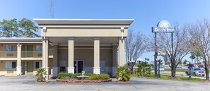 A Days Inn with a simple facade, a covered entrance, and a parking lot. - Days Inn by Wyndham Shenandoah (Shenandoah)