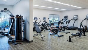 A gym with various exercise equipment, including treadmills, elliptical machines, and weight machines.