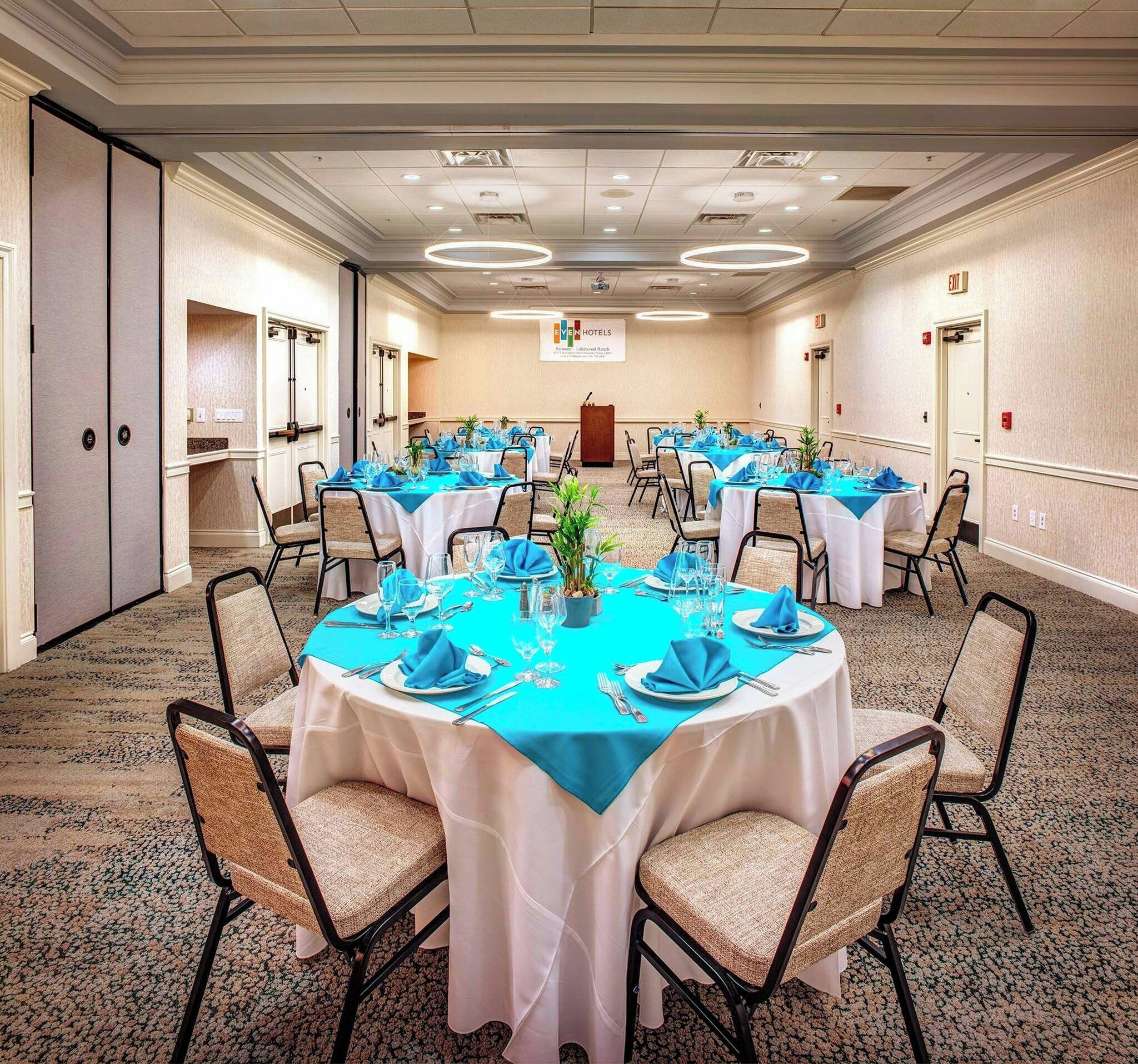 A conference room with round tables, chairs, and a podium.