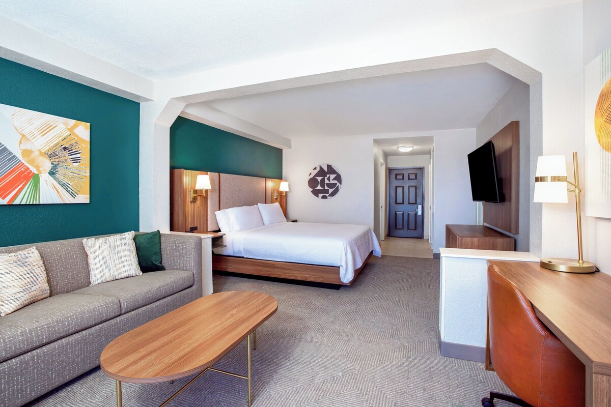 Een hotelkamer met een bed, een bank, een bureau en een televisie.