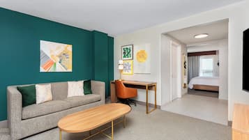 A hotel room with a sofa, a desk, and a bed.