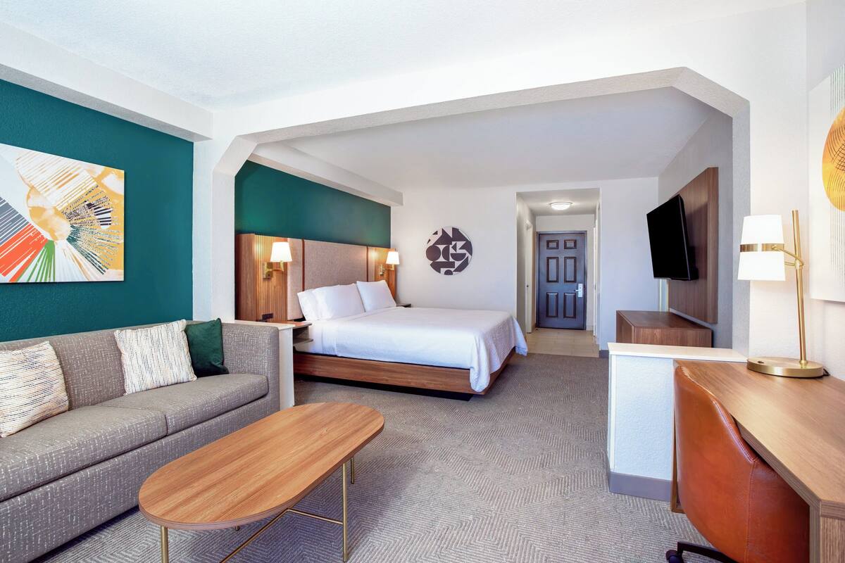 Een hotelkamer met een bed, een bank, een bureau en een televisie.