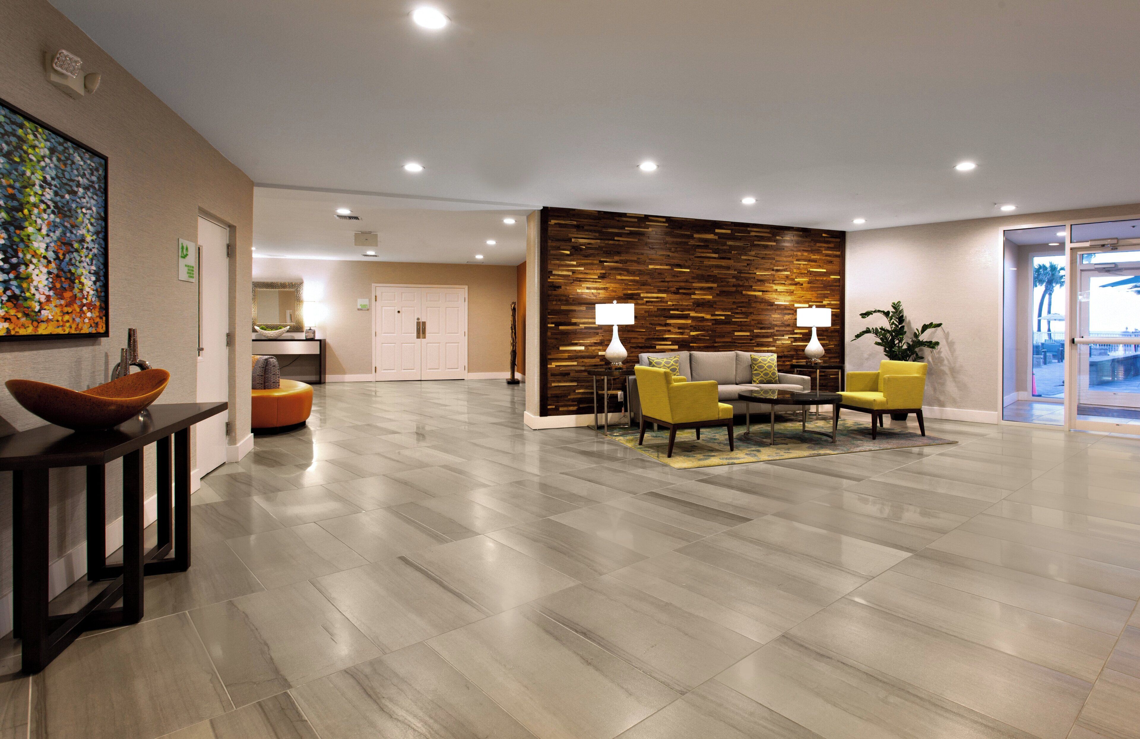 A modern lobby with a reception desk, seating area, and a decorative wall.
