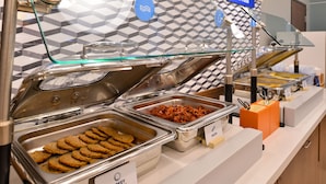 Un bufé con recipientes etiquetados de salchicha de pavo y galletas.