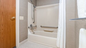 A bathroom with a bathtub, a shower, and a wooden door. - Holiday Inn Express Hotel & Suites Canton by IHG (Canton)