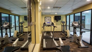 Un gimnasio con cintas de correr, elípticas y bicicletas estáticas.