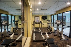A gym with treadmills, elliptical machines, and stationary bikes.