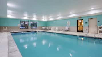 A swimming pool with lounge chairs and a door marked 'EXIT'.