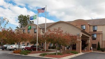 Welcome to the Holiday Inn Express, featuring a brick facade and landscaped grounds with red-leaved trees.