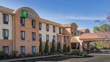 Edificio Holiday Inn Express con fachada de ladrillo, varias ventanas y un estacionamiento.