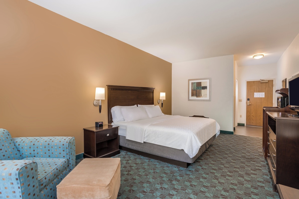 Una habitación de hotel con cama, sofá, escritorio y cómoda.