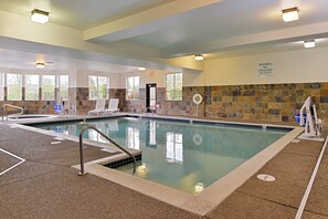 An indoor swimming pool with clear water, tiled walls, and a lifeguard chair. - Holiday Inn Express & Suites Albany by IHG (Albany)