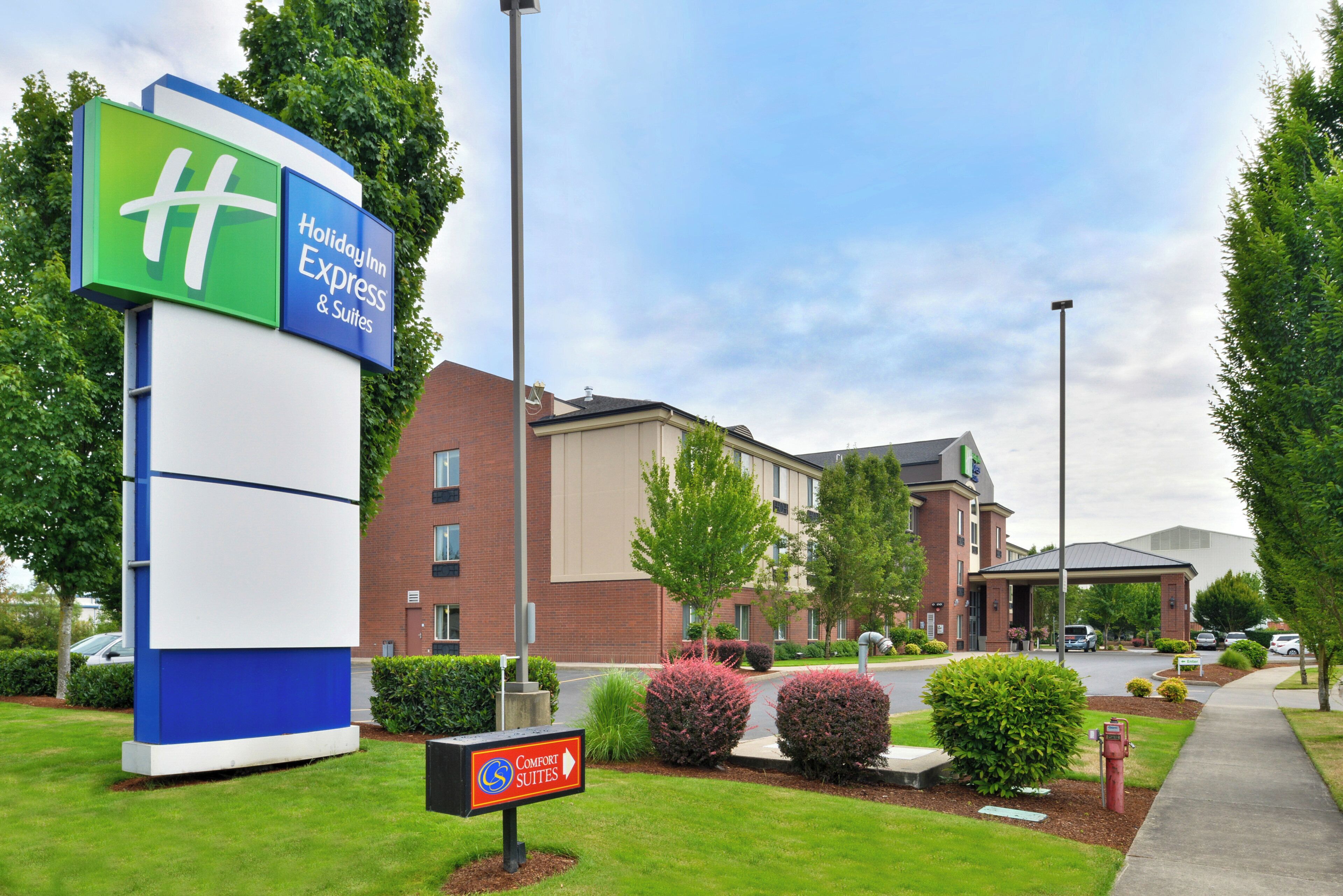 A Holiday Inn Express & Suites sign, a brick building, and a Comfort Suites sign.
