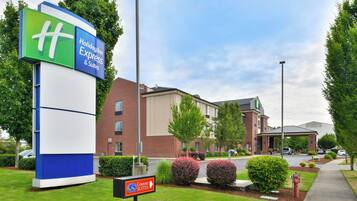 A Holiday Inn Express & Suites sign, a brick building, and a Comfort Suites sign.
