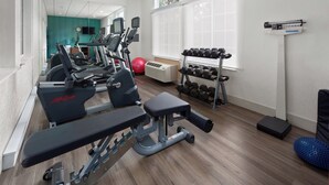A gym with treadmills, a bench press, dumbbells, and a red exercise ball. - Holiday Inn Express Hotel & Suites Acme-Traverse City by IHG (Williamsburg)