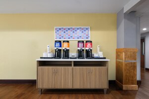 A coffee station with four dispensers labeled DARK ROAST, LIGHT ROAST, DECAF ROAST, and HOT WATER.