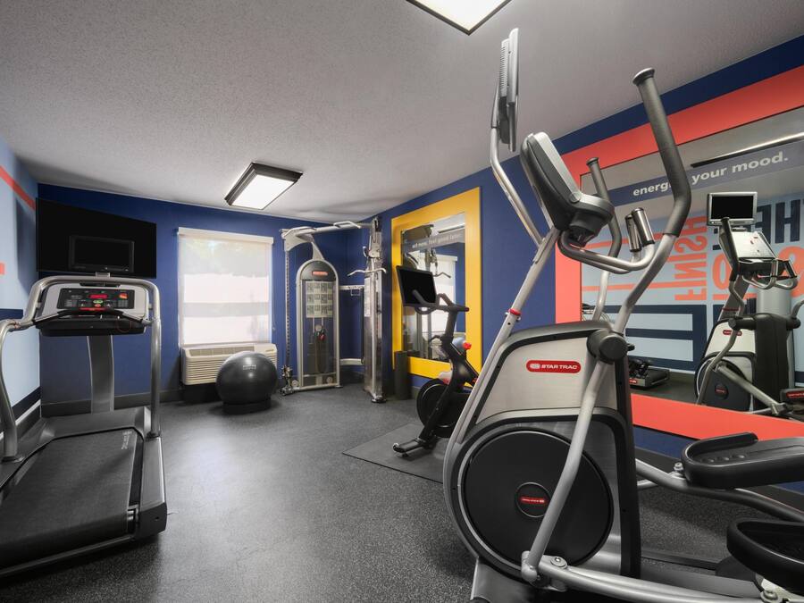 A gym with treadmills, an elliptical, and a stationary bike.