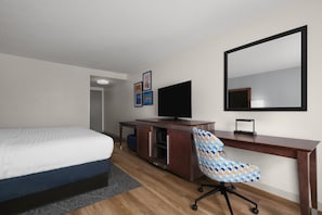 A hotel room with a bed, a desk, a chair, a television, and a mirror. - Hampton Inn Havelock (Havelock)