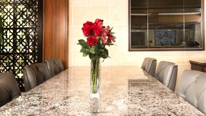 A conference table with a vase of red roses in the center, surrounded by leather chairs. - Ayres Hotel Laguna Woods - Aliso Viejo (Laguna Woods)