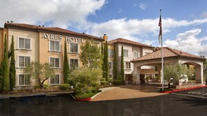 A hotel with a tiled roof, multiple windows, and a flag. - Ayres Hotel Laguna Woods - Aliso Viejo (Laguna Woods)